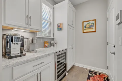 a kitchen with stainless steel appliances granite countertop a lot of cabinets a stove and a wooden floor