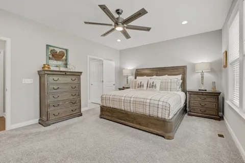 a bedroom with a large bed and a flat tv screen on dresser