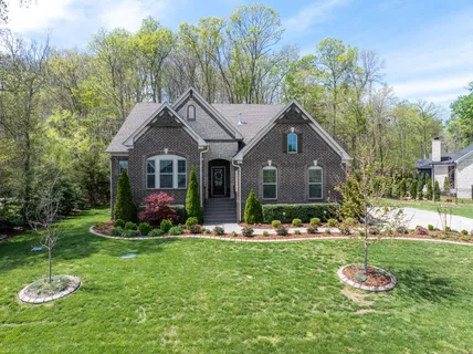 a front view of a house with a yard and trees