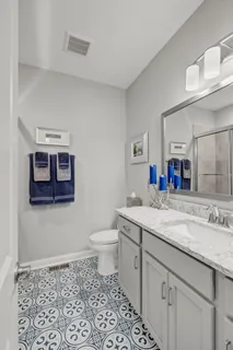 a bathroom with a granite countertop sink a toilet and a mirror