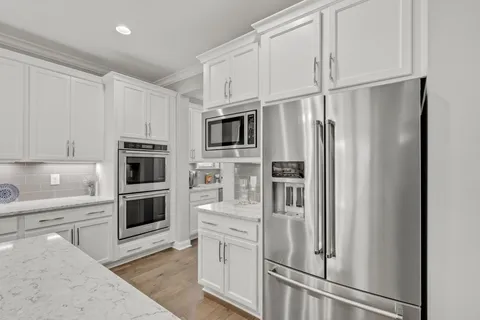 a large kitchen with kitchen island a sink a stove a center island and living room view