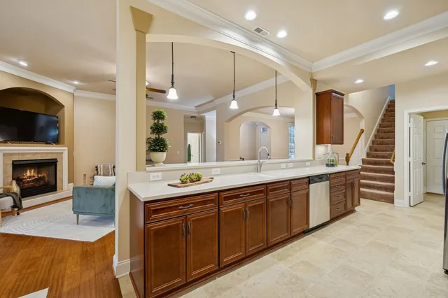 a large white kitchen with a large window and stainless steel appliances