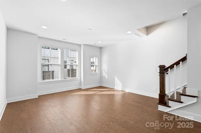 a view of a room with wooden floor and windows