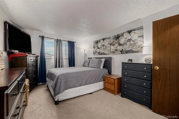 a spacious bedroom with a bed and a flat screen tv