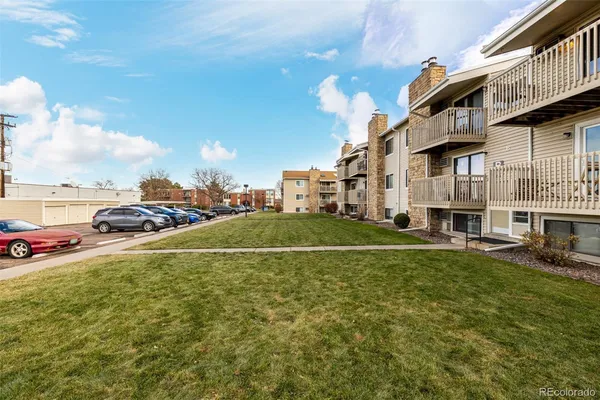 a view of a house with a big yard and large trees
