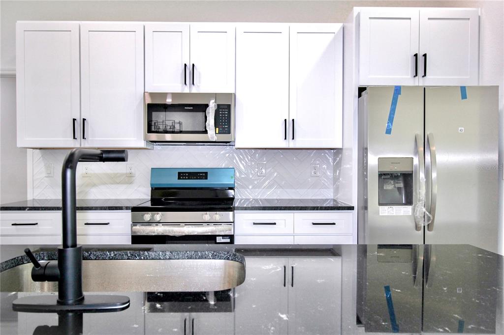 454 Bonnie Road Northwest Lake Placid, FL 33852 - Photo 11 of 30 a kitchen with stainless steel appliances granite countertop a stove a sink and a refrigerator