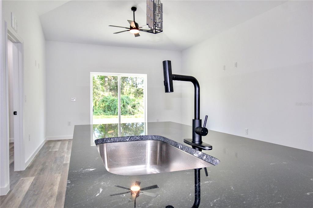 454 Bonnie Road Northwest Lake Placid, FL 33852 - Photo 4 of 30 a dining table with a sink and chandelier