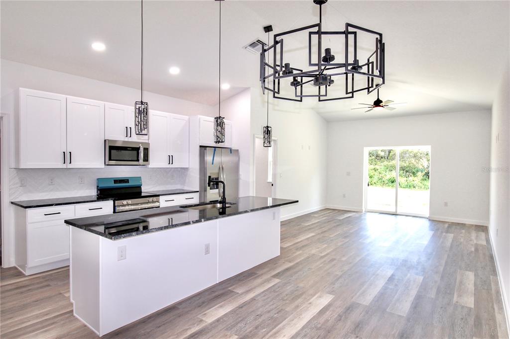 454 Bonnie Road Northwest Lake Placid, FL 33852 - Photo 7 of 30 a kitchen with stainless steel appliances a white refrigerator oven a stove and white cabinets
