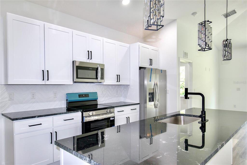 454 Bonnie Road Northwest Lake Placid, FL 33852 - Photo 8 of 30 a kitchen with stainless steel appliances granite countertop a sink a stove and a refrigerator