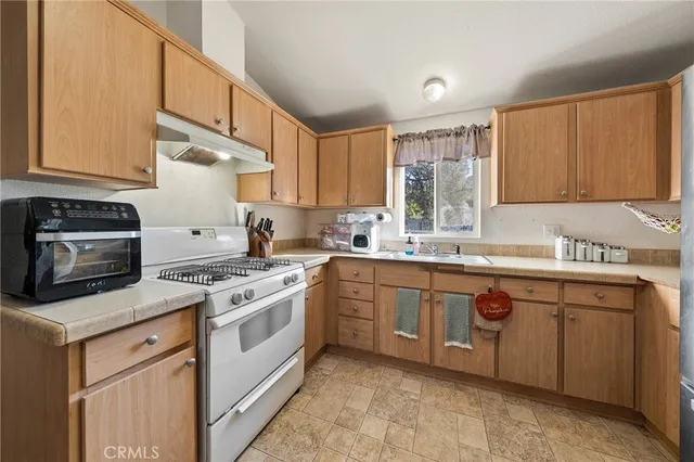 a kitchen with a stove sink and cabinets