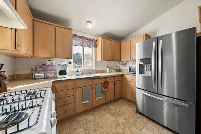 a kitchen with stainless steel appliances granite countertop a refrigerator sink and cabinets