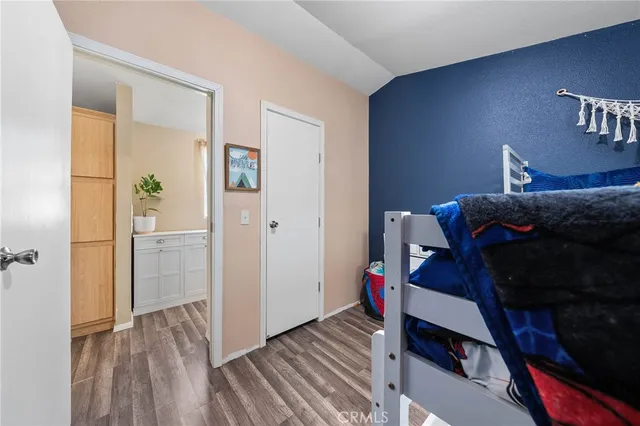 a view of a bedroom with a bed and wooden floor