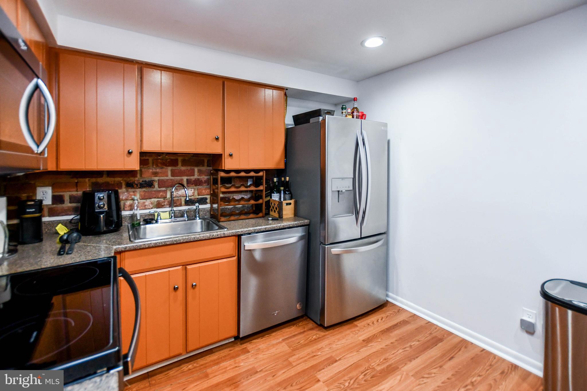 8317 Canning Terrace Greenbelt, MD 20770 - Photo 12 of 50 a kitchen with stainless steel appliances granite countertop a refrigerator a stove a sink and dishwasher with wooden floor