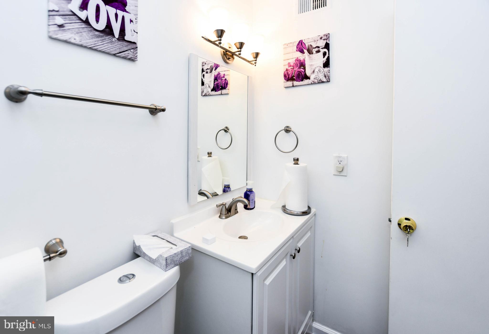 8317 Canning Terrace Greenbelt, MD 20770 - Photo 26 of 50 a bathroom with a sink and mirror with toilet