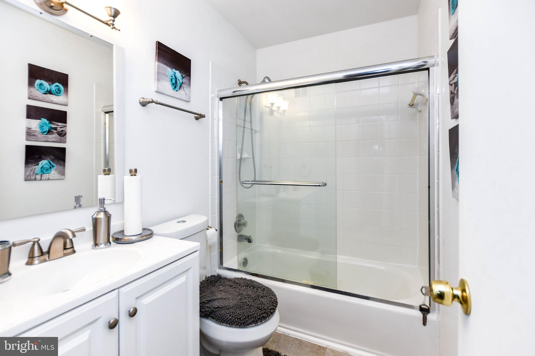8317 Canning Terrace Greenbelt, MD 20770 - Photo 30 of 50 a bathroom with a shower a sink and a mirror