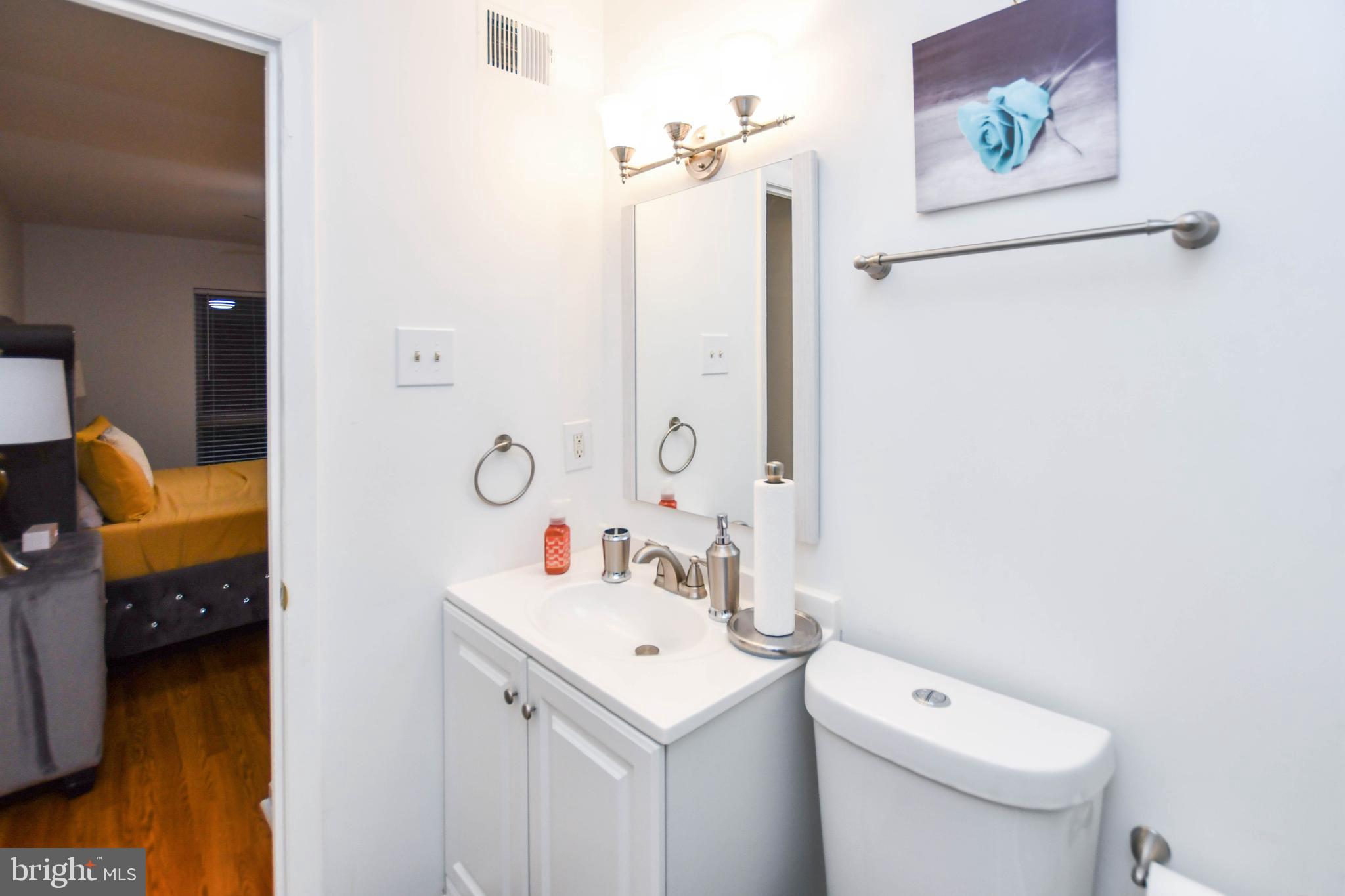 8317 Canning Terrace Greenbelt, MD 20770 - Photo 32 of 50 a bathroom with a toilet sink and mirror