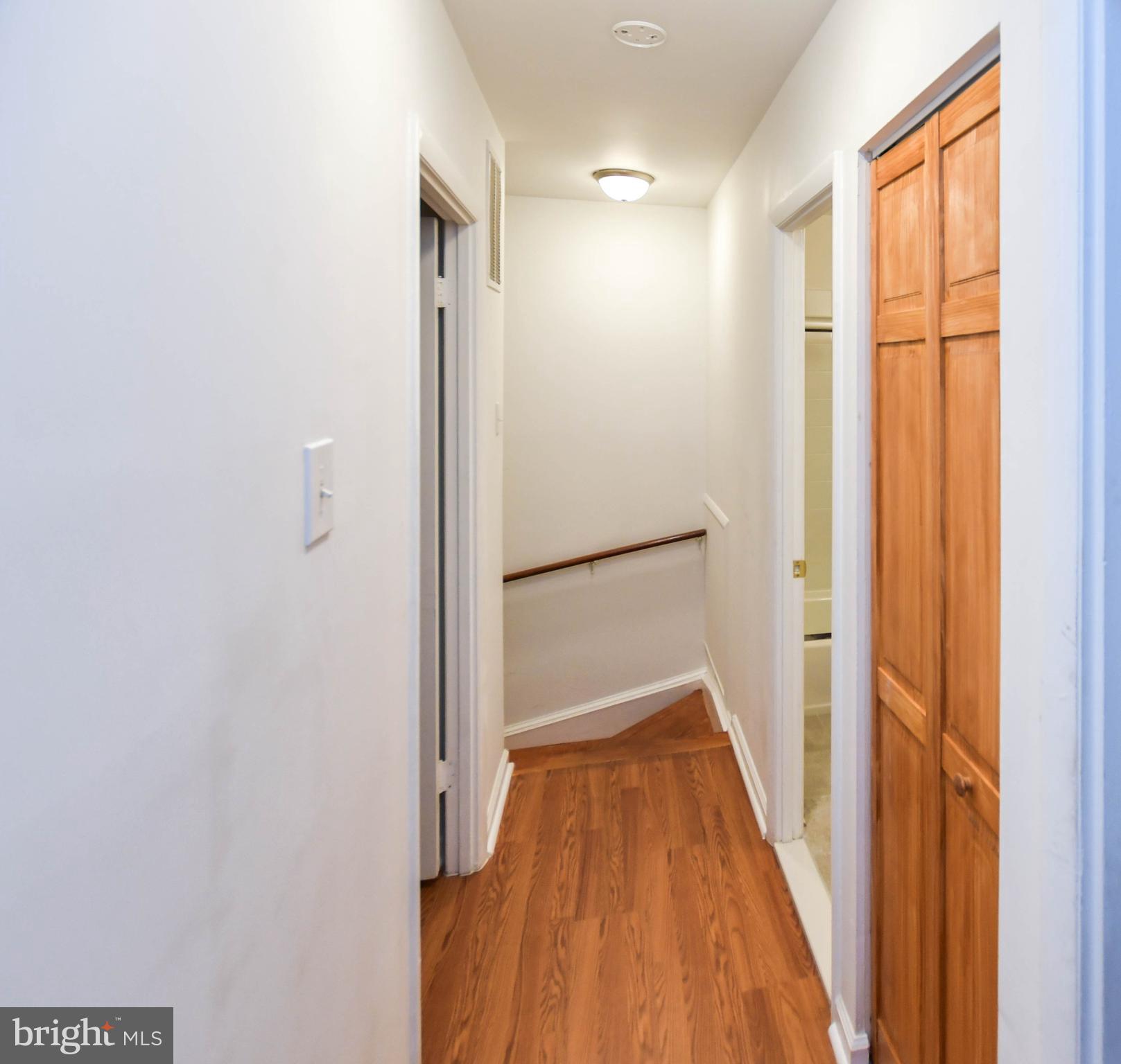 8317 Canning Terrace Greenbelt, MD 20770 - Photo 36 of 50 a view of a hallway with wooden floor and a bathroom