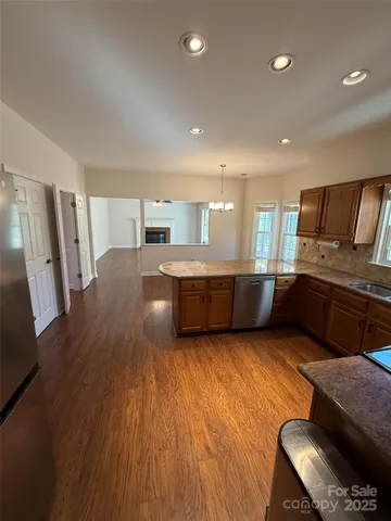 a large kitchen with stainless steel appliances wooden floors and a counter top space
