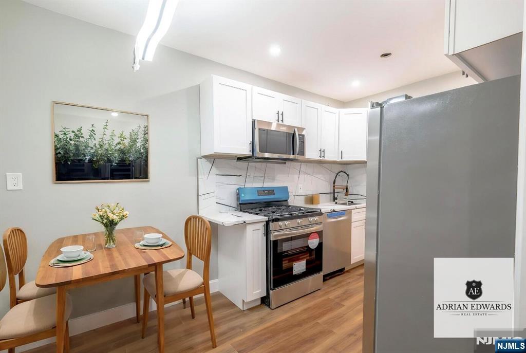155 Union Avenue, Unit 201 Rutherford, NJ 07070 - Photo 14 of 15 a kitchen with stainless steel appliances granite countertop a stove top oven a sink dishwasher and a refrigerator with wooden floor