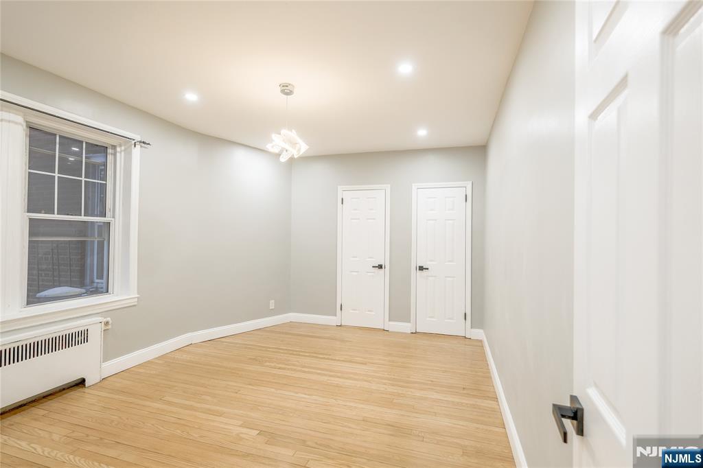 155 Union Avenue, Unit 201 Rutherford, NJ 07070 - Photo 6 of 15 a view of an empty room with wooden floor and a window