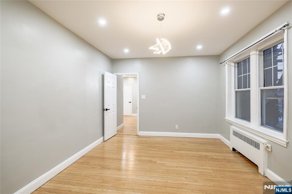 155 Union Avenue, Unit 201 Rutherford, NJ 07070 - Photo 8 of 15 an empty room with wooden floor and windows