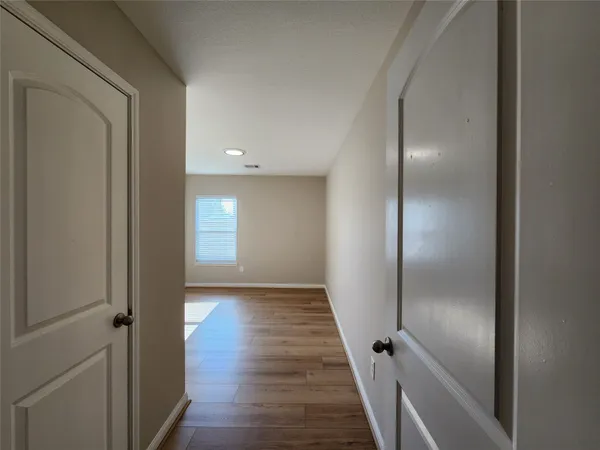 a view of a hallway with wooden floor