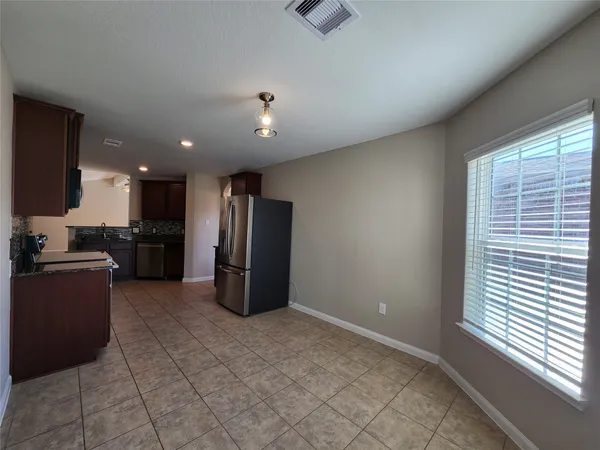 a kitchen with a refrigerator and a stove top oven