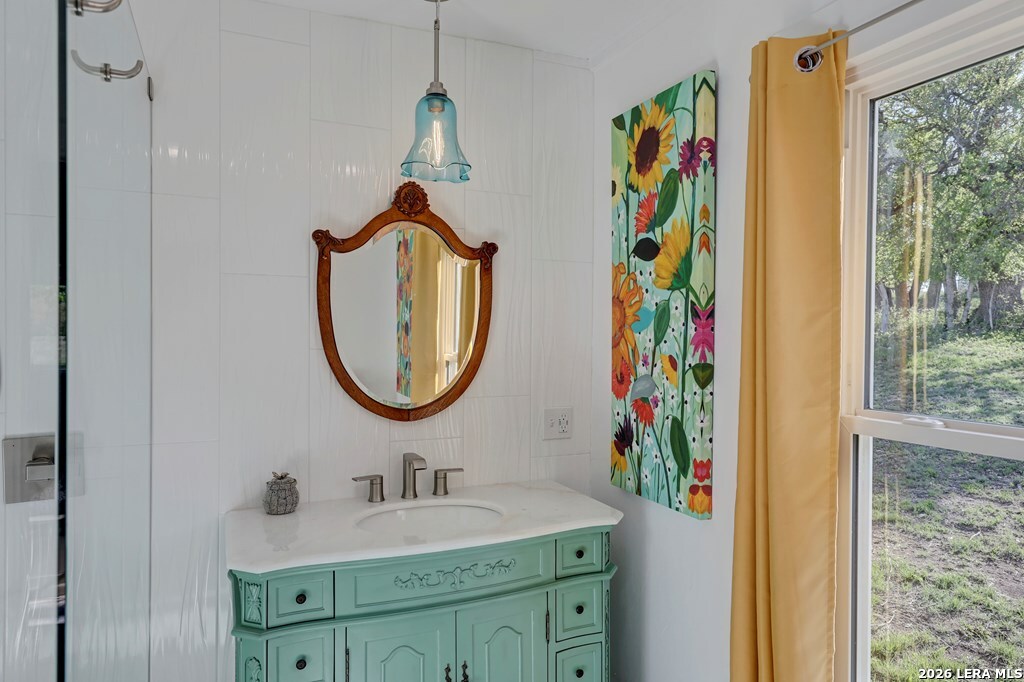 283 2nd Street Harper, TX 78631 - Photo 13 of 46 a bathroom with a sink a mirror and a shower curtain