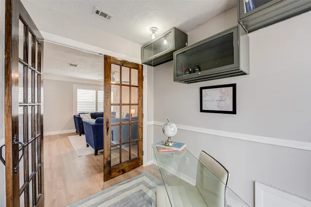 a living room with furniture a flat screen tv and a refrigerator