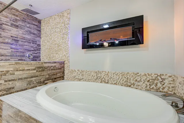 a bathroom with a bathtub and mirror