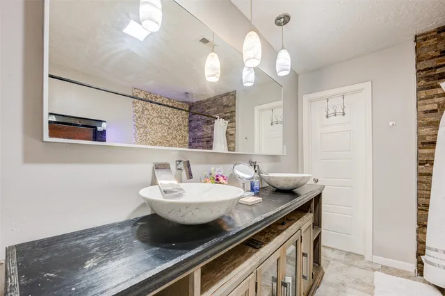 a bathroom with a granite countertop sink a large mirror and vanity