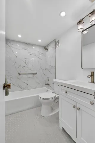 a bathroom with a toilet a sink a mirror and bathtub