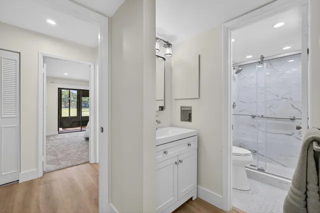 a bathroom with a sink a toilet a mirror and shower