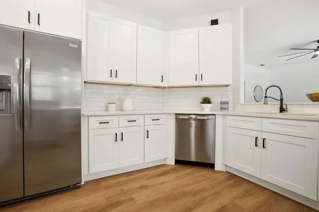a kitchen with white cabinets and white appliances
