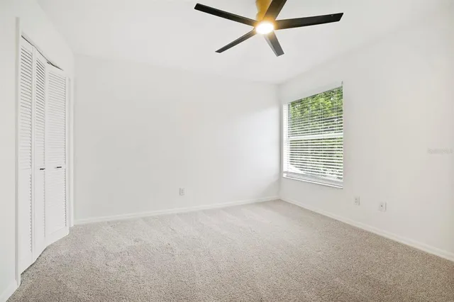 an empty room with a window and a fan