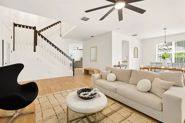 a living room with furniture and a wooden floor