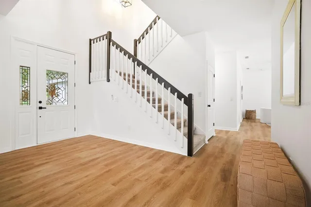 a view of a hallway with wooden floor and entryway