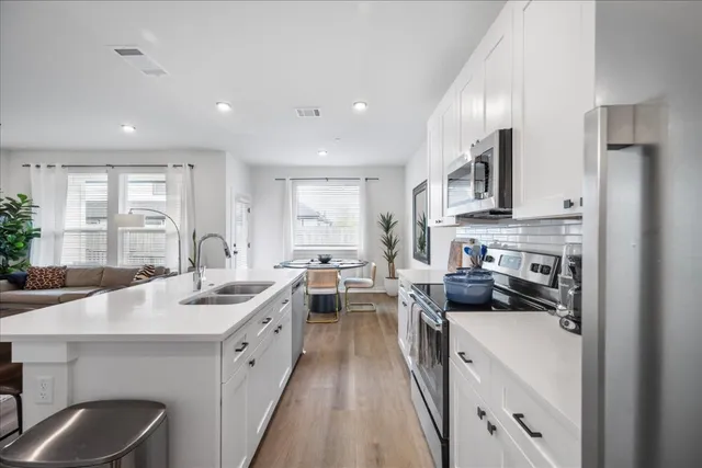 a living room kitchen with furniture and a large window