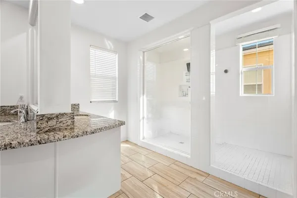 a bathroom with a granite countertop sink and a mirror