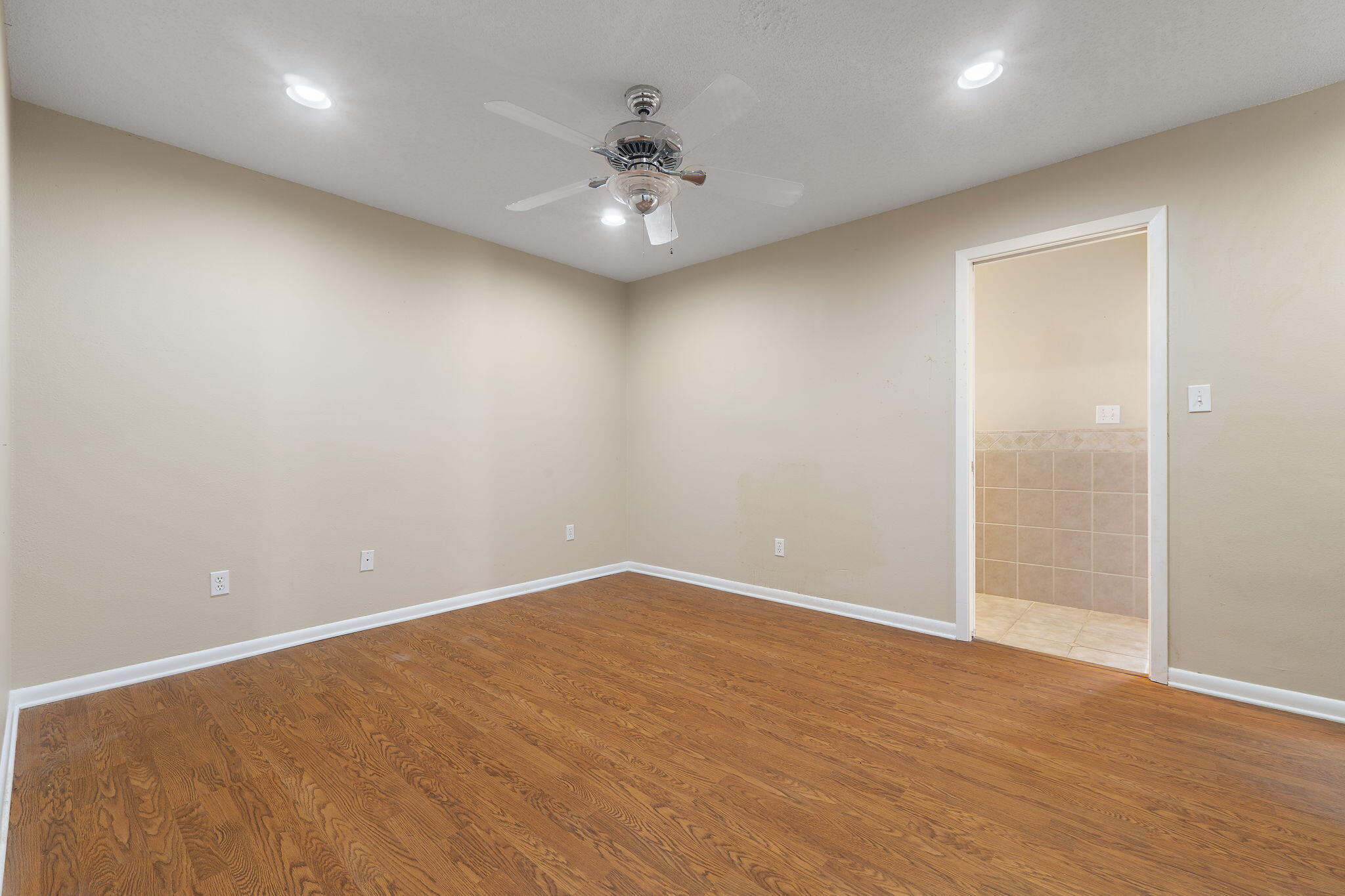 12 Hillcrest Drive Shalimar, FL 32579 - Photo 28 of 45 an empty room with a chandelier fan and wooden floor