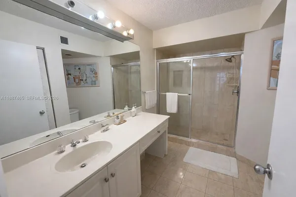 a bathroom with a sink a shower and a mirror