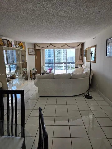 a living room with furniture and a floor to ceiling window