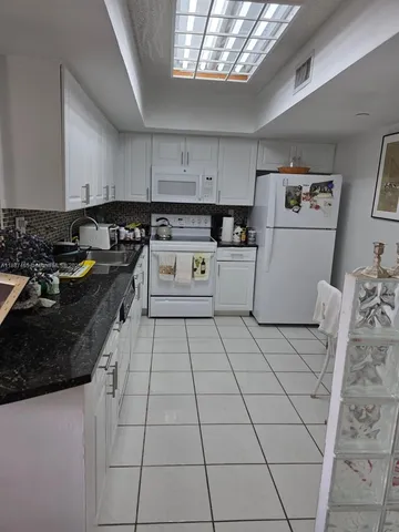 a kitchen with a sink a stove and cabinets
