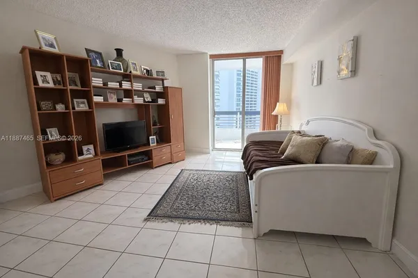 a living room with furniture a flat screen tv and a window
