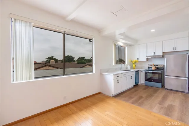 a kitchen with granite countertop a refrigerator stove and sink