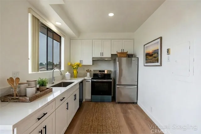 a kitchen with granite countertop a refrigerator and a sink