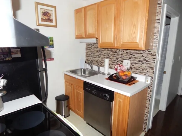 a kitchen with stainless steel appliances a sink a stove a refrigerator and cabinets