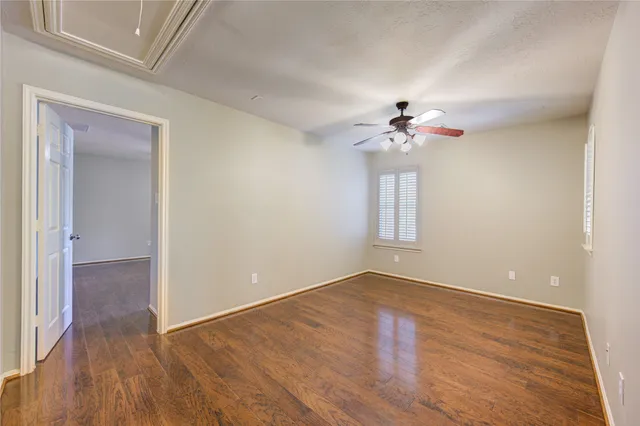 a view of a room with wooden floor and a ceiling fan