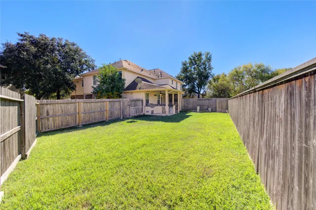a view of a house with a small yard and wooden fence