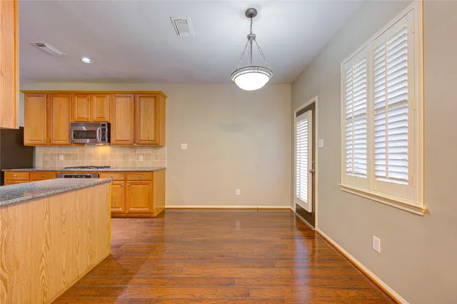 a view of a kitchen with stainless steel appliances granite countertop a sink and cabinets